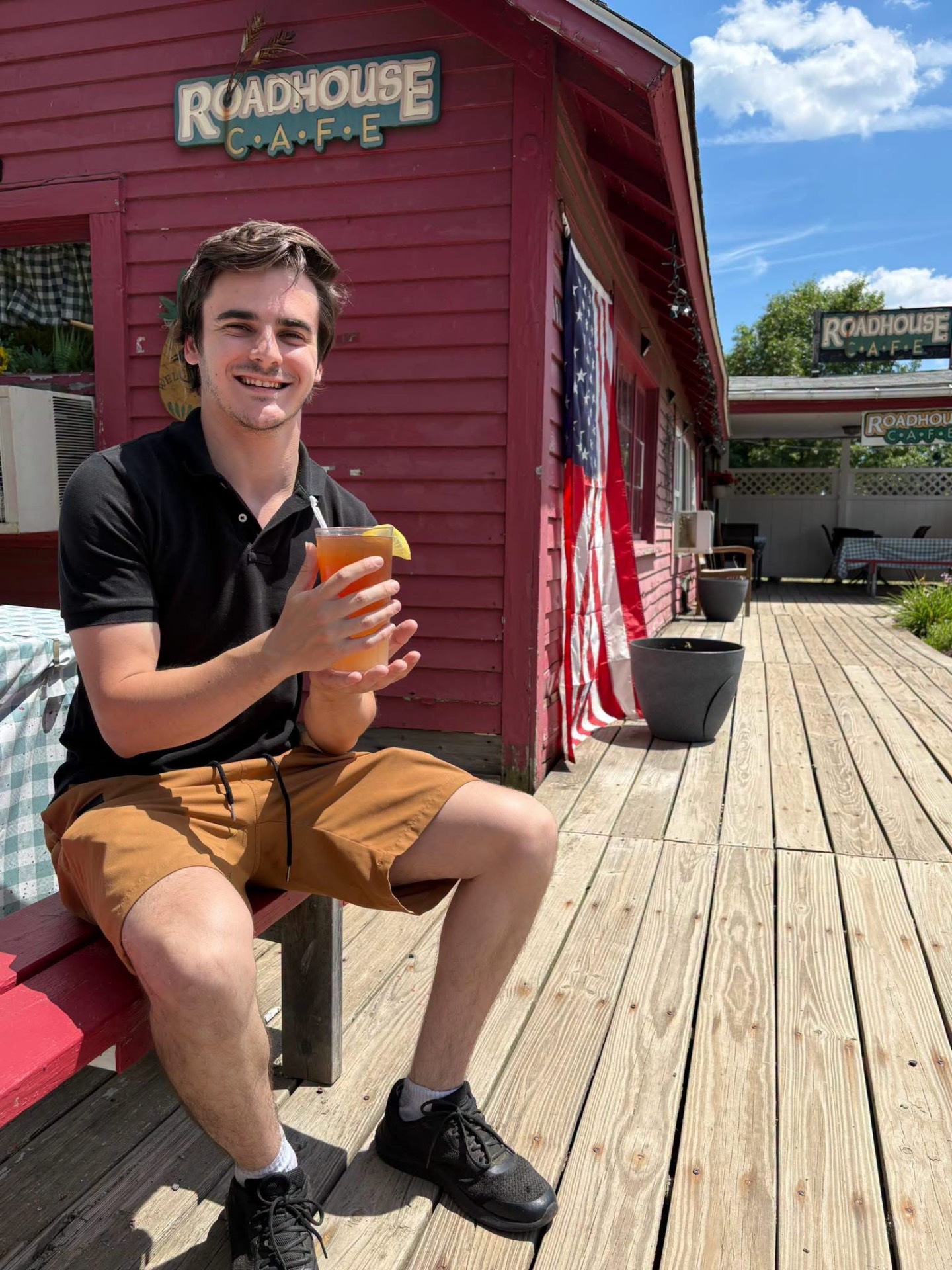 Guest enjoying a cold drink on the wooden deck at Roadhouse Cafe