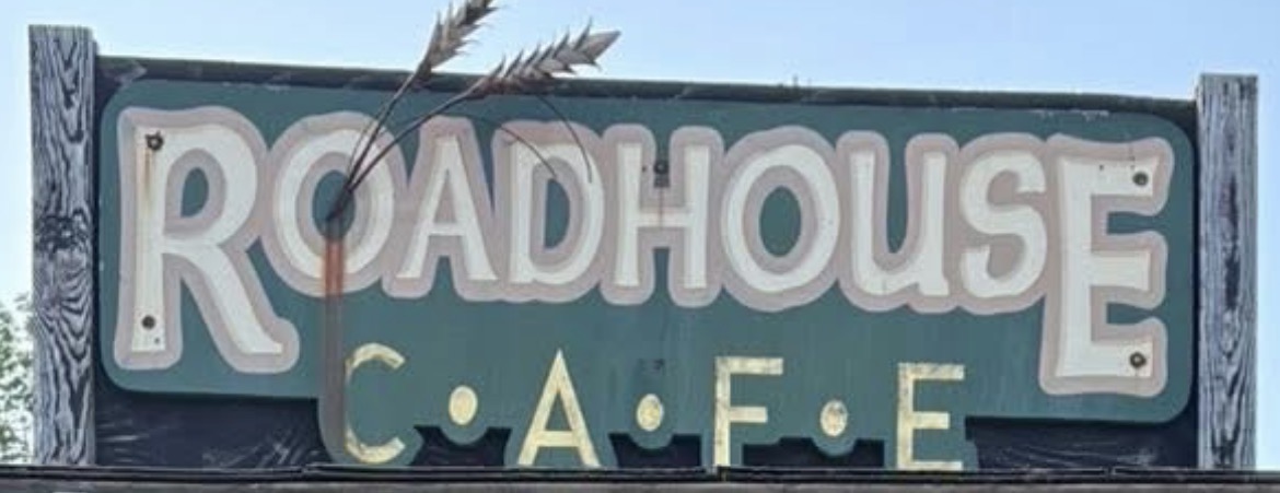 Hand-painted wooden Roadhouse Cafe sign with wheat stalks