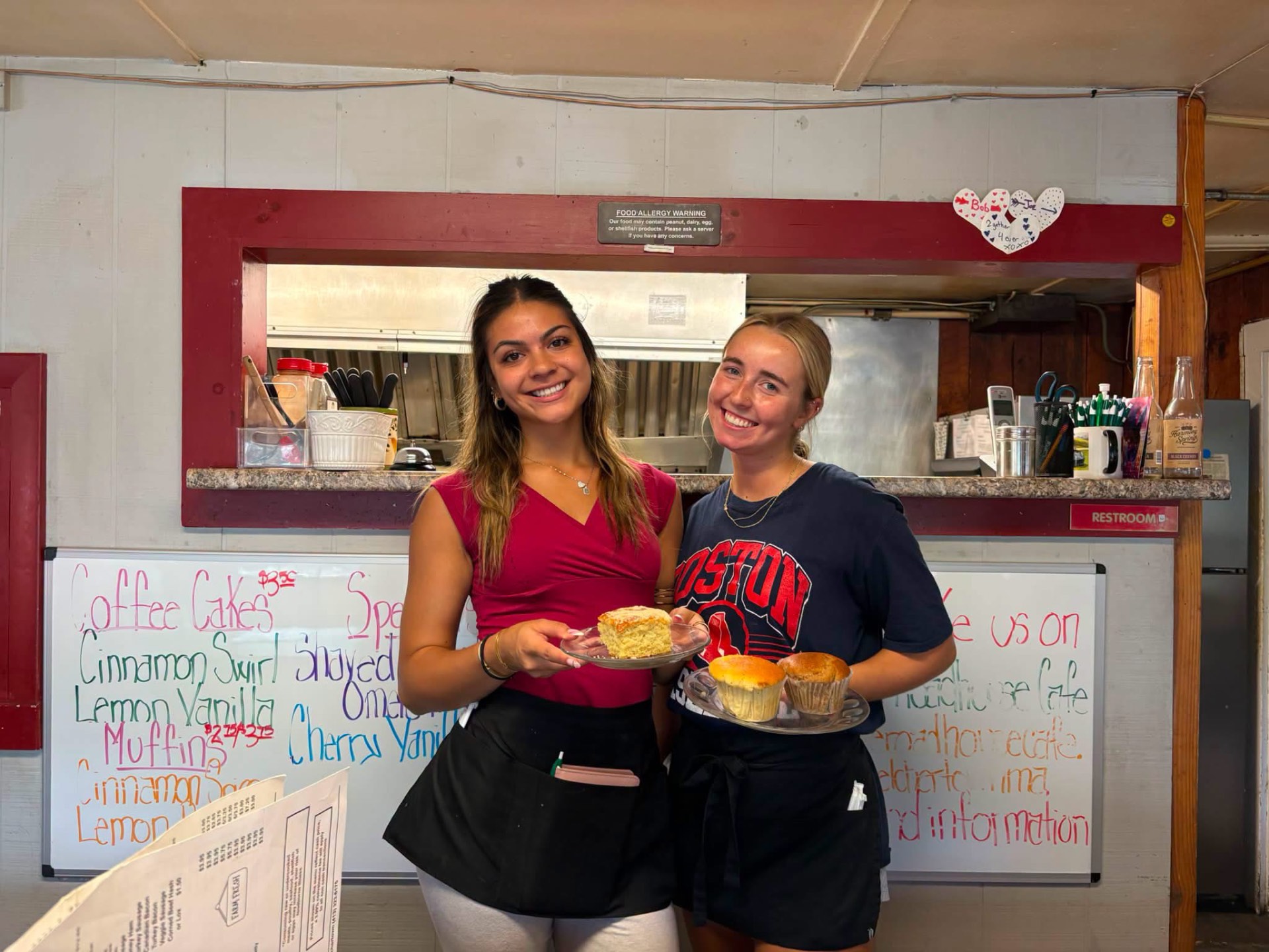 Servers holding homemade coffee cake and a muffin inside Roadhouse Cafe
